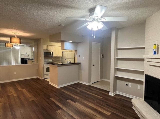 kitchen featuring a textured ceiling, white appliances, dark hardwood / wood-style floors, and pendant lighting