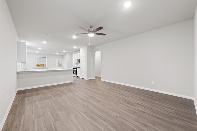 unfurnished living room featuring ceiling fan and light hardwood / wood-style flooring