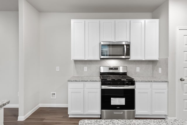 kitchen featuring decorative backsplash, light stone counters, white cabinetry, and stainless steel appliances