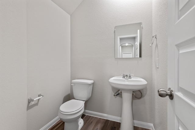 bathroom featuring hardwood / wood-style floors, toilet, sink, and vaulted ceiling