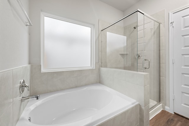 bathroom with separate shower and tub and wood-type flooring