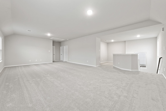 spare room with light colored carpet and vaulted ceiling