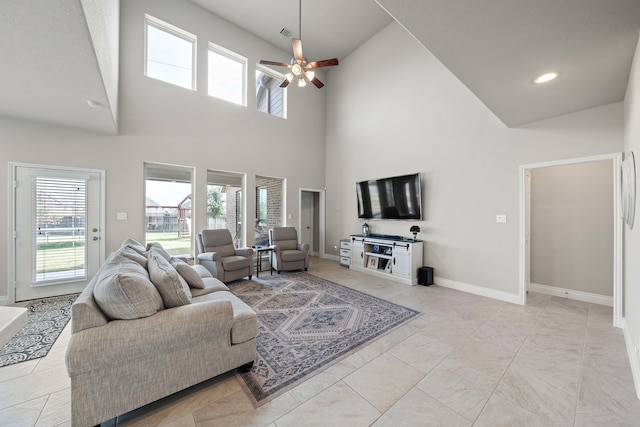 living room featuring a towering ceiling and ceiling fan