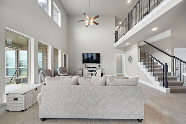 living room featuring a high ceiling, light tile patterned floors, and ceiling fan