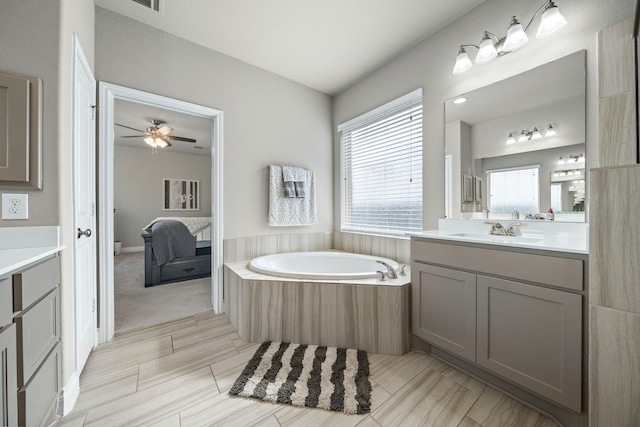 bathroom featuring vanity, ceiling fan, and a bathing tub