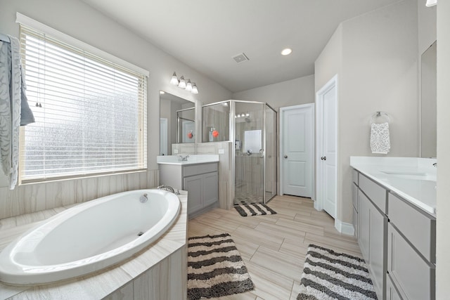 bathroom featuring separate shower and tub, a wealth of natural light, and vanity