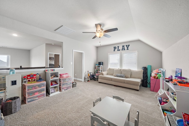 recreation room with carpet flooring, ceiling fan, a textured ceiling, and vaulted ceiling