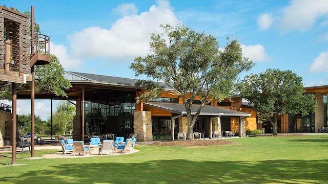 view of property's community with a patio and a lawn