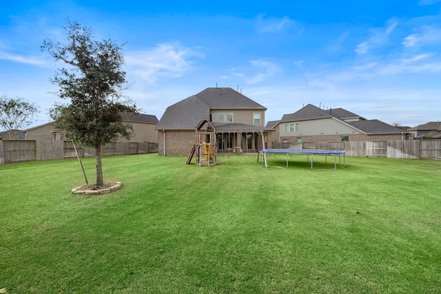 view of yard featuring a trampoline and a playground