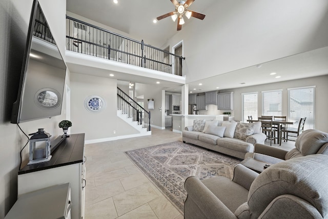 living room featuring ceiling fan and a towering ceiling