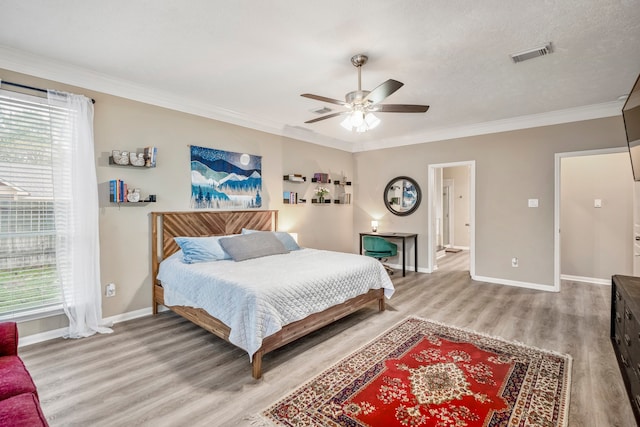 bedroom featuring multiple windows, ceiling fan, crown molding, and wood-type flooring