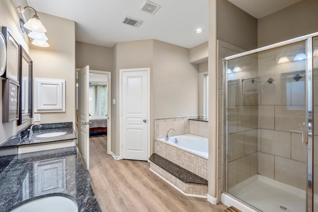 bathroom featuring vanity, wood-type flooring, and shower with separate bathtub