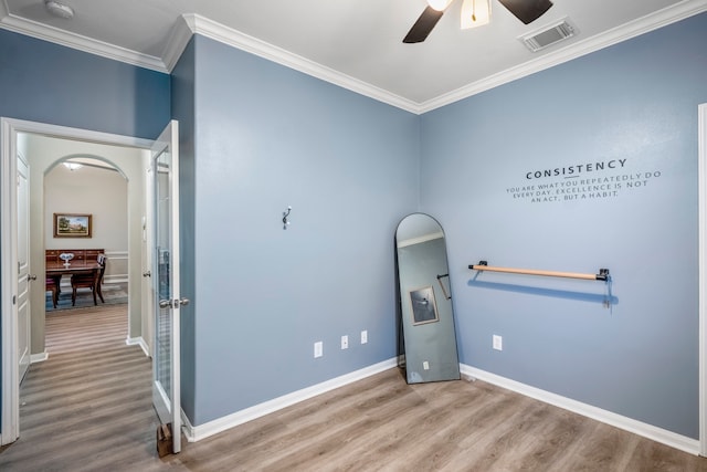 interior space featuring ceiling fan, wood-type flooring, and ornamental molding