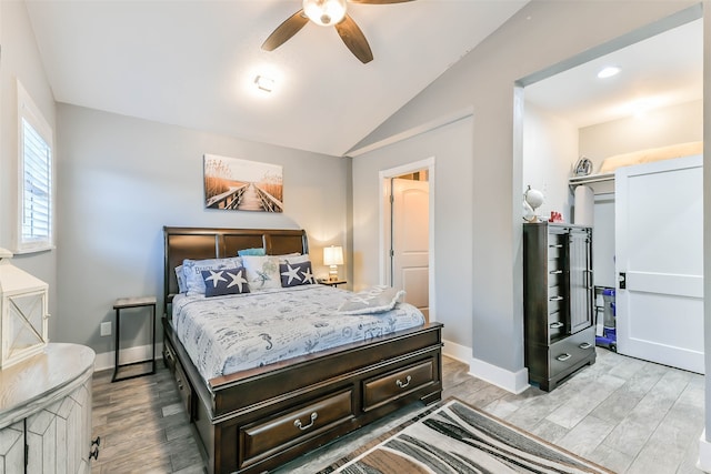 bedroom with ceiling fan, vaulted ceiling, and light wood-type flooring