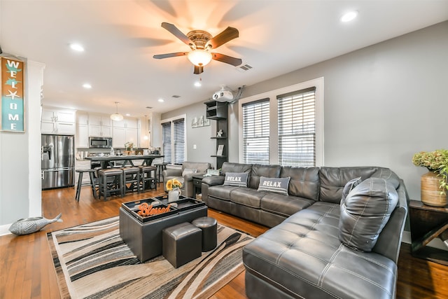 living room with ceiling fan and light hardwood / wood-style flooring