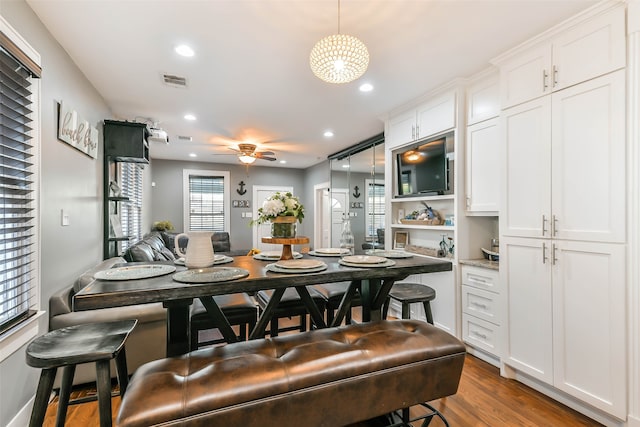 dining space with ceiling fan and dark wood-type flooring