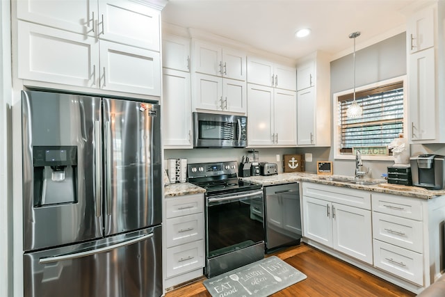 kitchen featuring sink, stainless steel appliances, dark hardwood / wood-style flooring, decorative light fixtures, and white cabinets