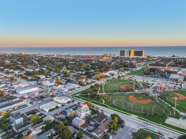 aerial view at dusk featuring a water view