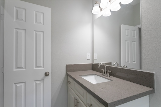 bathroom featuring a notable chandelier and vanity