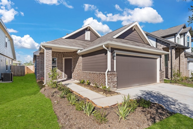 view of front of home featuring a front yard, a garage, and central air condition unit