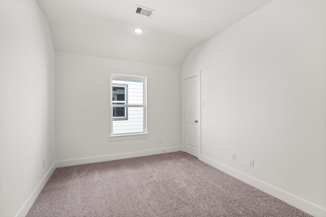 carpeted spare room with lofted ceiling