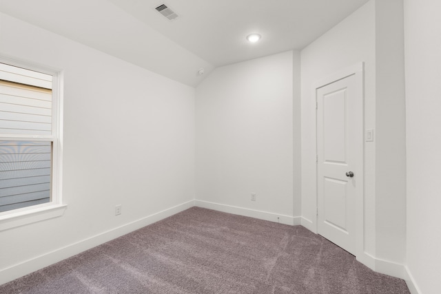 unfurnished room featuring carpet flooring and lofted ceiling