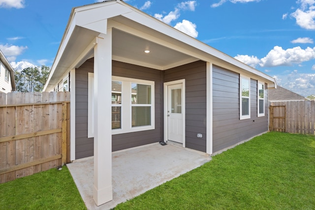 view of exterior entry with a patio area and a yard