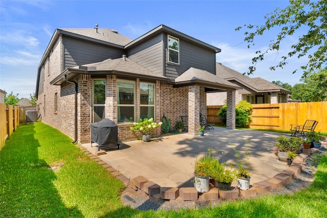 rear view of property featuring a lawn and a patio area