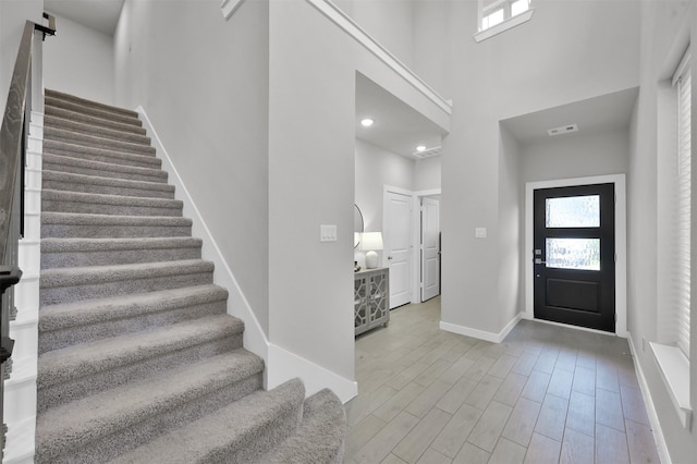 entryway featuring a high ceiling and light hardwood / wood-style flooring