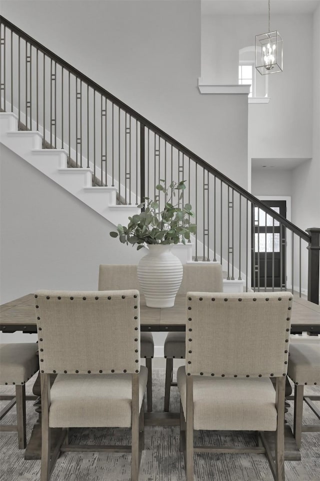 dining space with a high ceiling and an inviting chandelier