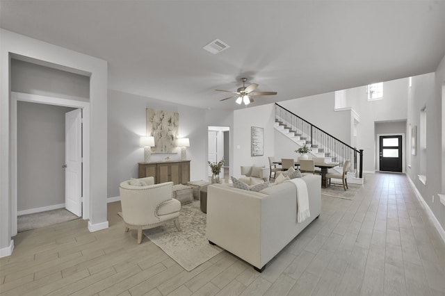 living room with ceiling fan and light hardwood / wood-style flooring