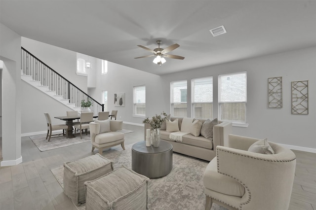 living room featuring light hardwood / wood-style flooring and ceiling fan