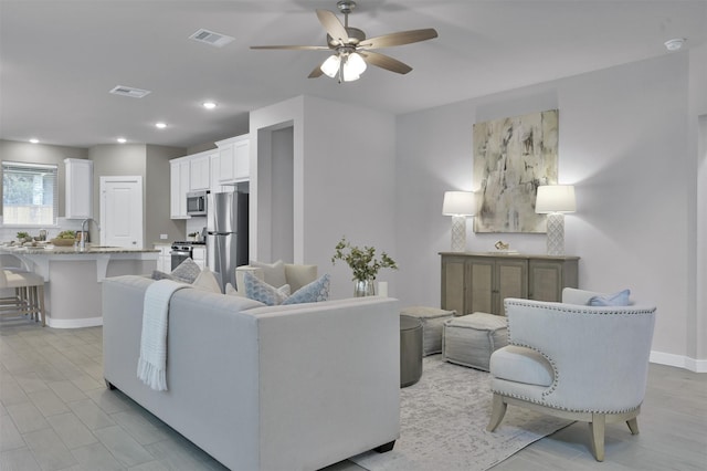 living room featuring ceiling fan and sink