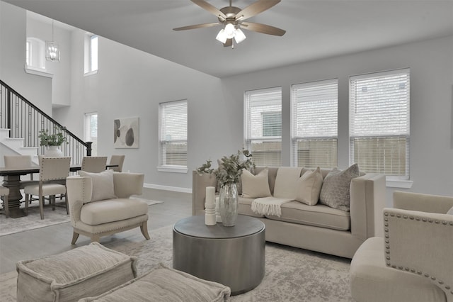 living room featuring ceiling fan with notable chandelier and light hardwood / wood-style floors