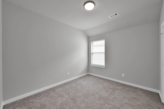 empty room with carpet and vaulted ceiling