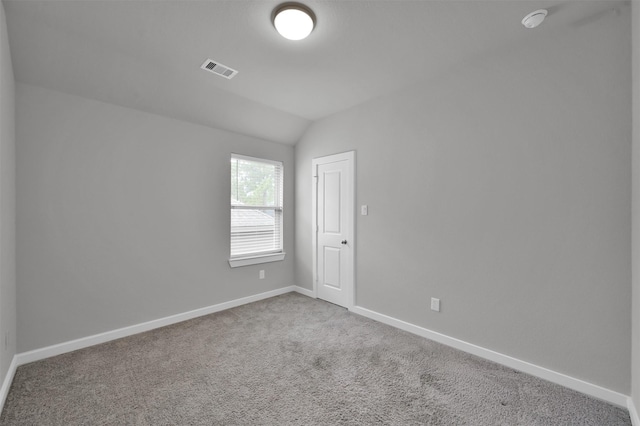 empty room featuring carpet floors and vaulted ceiling