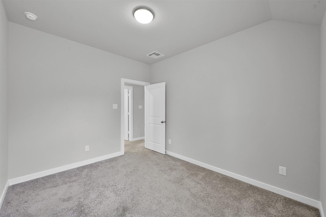 carpeted empty room with lofted ceiling