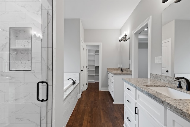 bathroom featuring plus walk in shower, wood-type flooring, and vanity