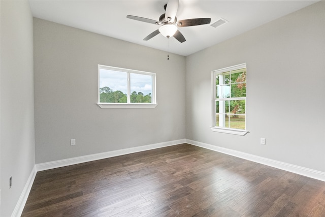 spare room with ceiling fan, a healthy amount of sunlight, and dark hardwood / wood-style floors