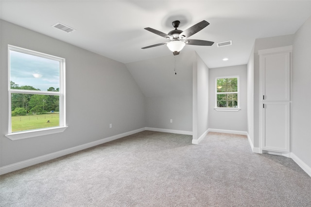 additional living space with ceiling fan, lofted ceiling, and light carpet