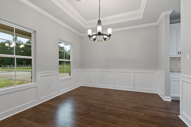 unfurnished dining area featuring a raised ceiling, crown molding, dark hardwood / wood-style floors, and a notable chandelier