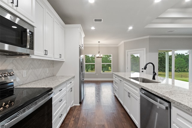 kitchen featuring dark wood-type flooring, sink, light stone countertops, appliances with stainless steel finishes, and a notable chandelier