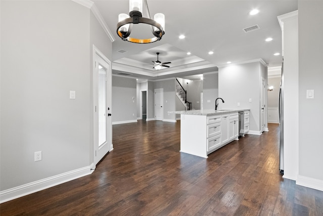 kitchen with light stone countertops, dark hardwood / wood-style flooring, white cabinetry, and ornamental molding