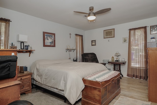 bedroom featuring multiple windows, ceiling fan, and light hardwood / wood-style flooring