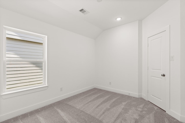 spare room with carpet flooring and lofted ceiling