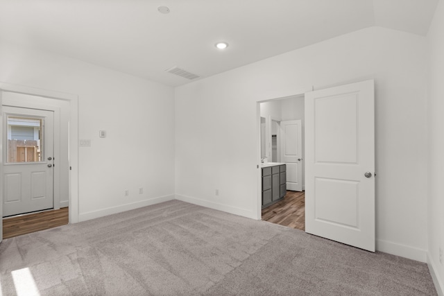 spare room with light carpet and lofted ceiling