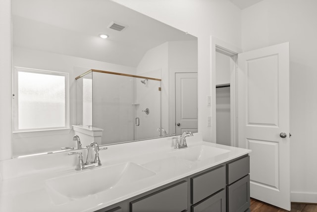 bathroom with hardwood / wood-style floors, vanity, and a shower with door