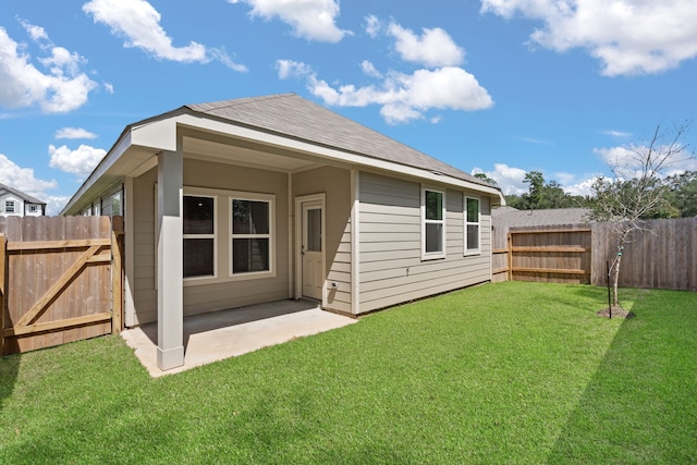 back of property featuring a patio area and a yard