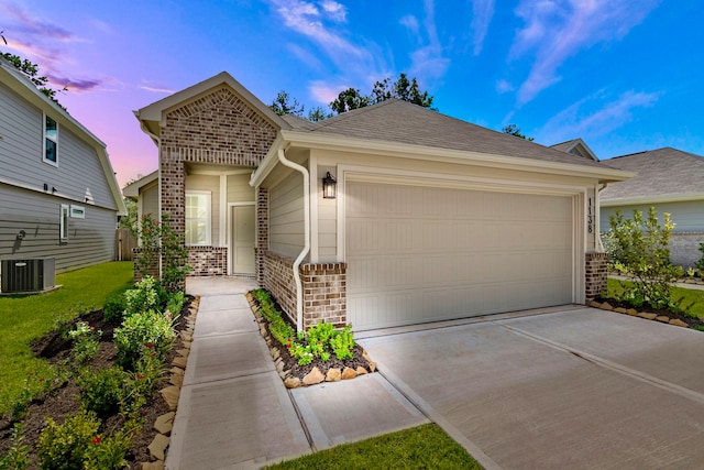 single story home featuring central air condition unit and a garage