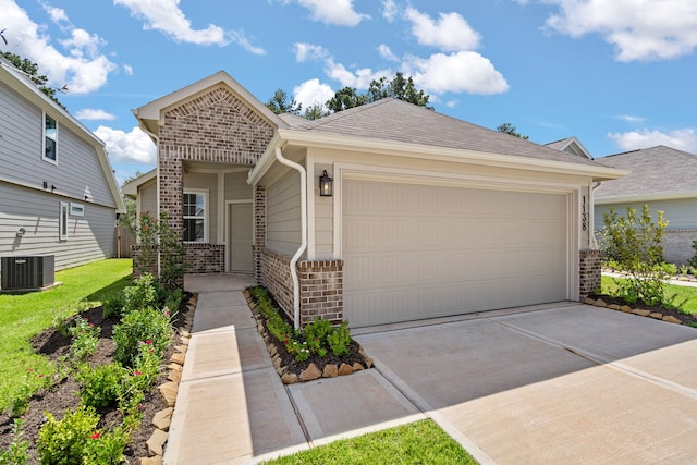 ranch-style house with a garage and central AC unit